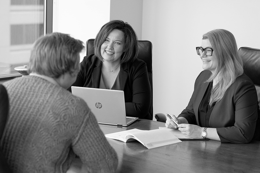 Photo of two of the Firm Attorneys discussing around a table with client
